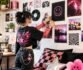 Gen Z decorating a colorful wall with posters in a stylish bedroom.