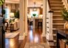 Welcoming home entryway with hardwood floors, carpeted staircase, and cozy living room.