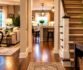 Welcoming home entryway with hardwood floors, carpeted staircase, and cozy living room.