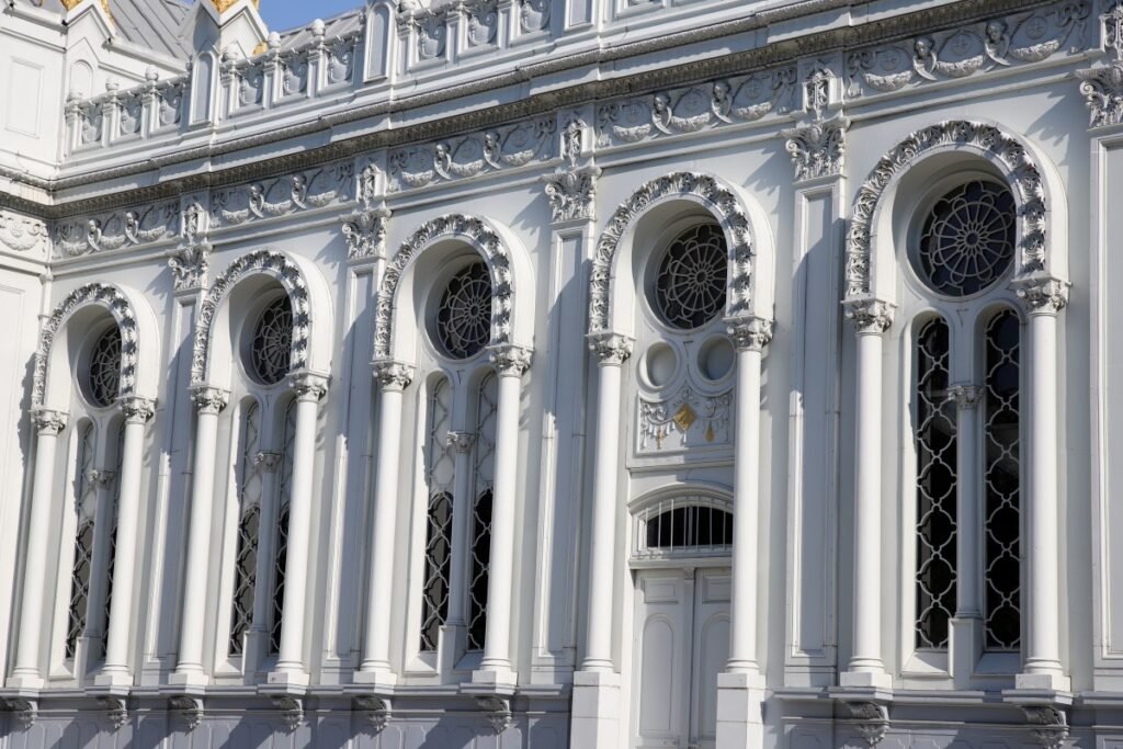 Ornate white classical building facade with arched windows and decorative details.