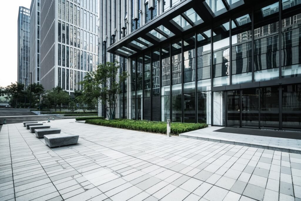 Modern high-rise office building with glass facade and landscaped plaza.