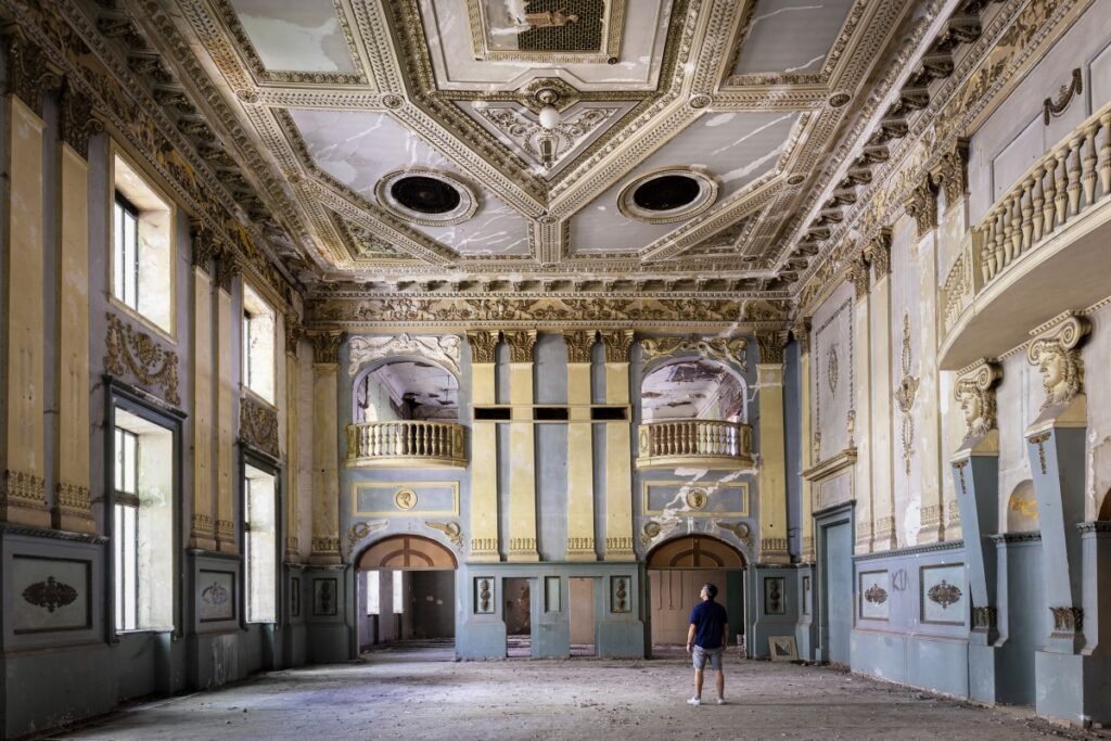 Ornate historic interior with decorative ceilings and classical columns.