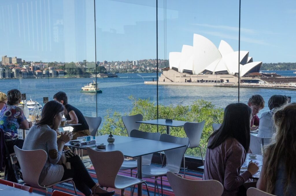 Restaurant with views of the Sydney Opera House and harbor through floor-to-ceiling windows.